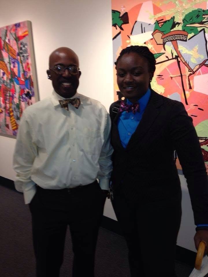 Sajdah and Dean Gilbert Holmes, both wearing bow ties, standing together at an art gallery event