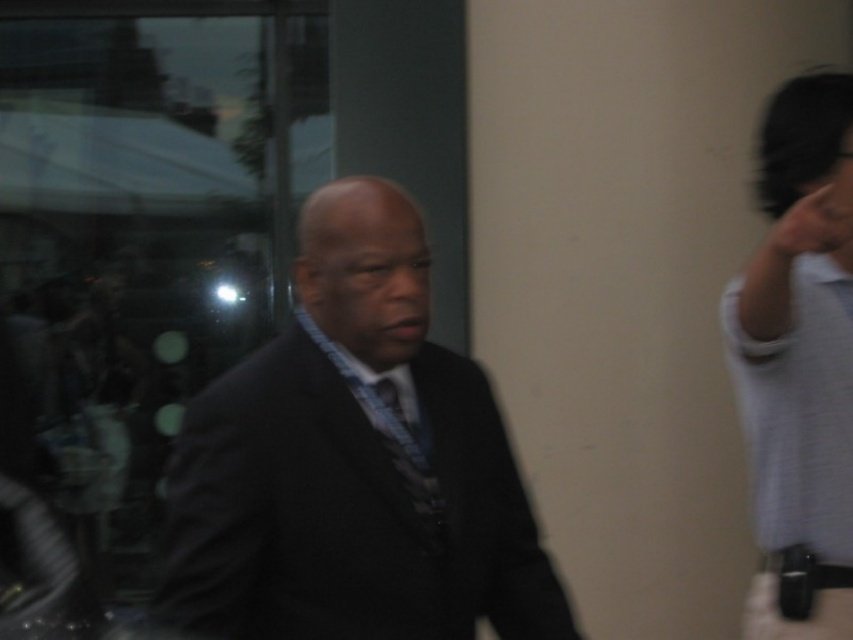 A man in a dark suit walking outdoors near the 2008 DNC venue