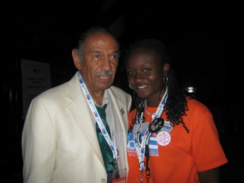 Sajdah smiling next to Congressman John Conyers at the 2008 DNC
