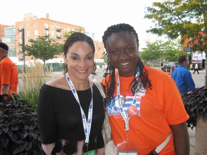Sajdah smiling next to a woman outdoors near the 2008 DNC, a Fox News sign visible behind them